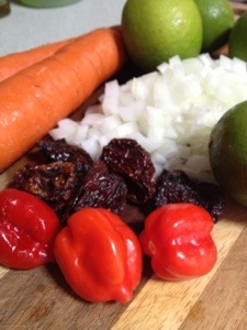 Fresh and dried Caribbean red peppers, onion, carrots and limes ready for the sauce.