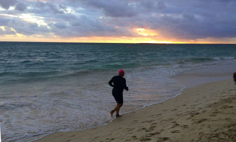 Running to swim lap two as the sun rises in the east. Mahalo for the photo by Kim Burnett.